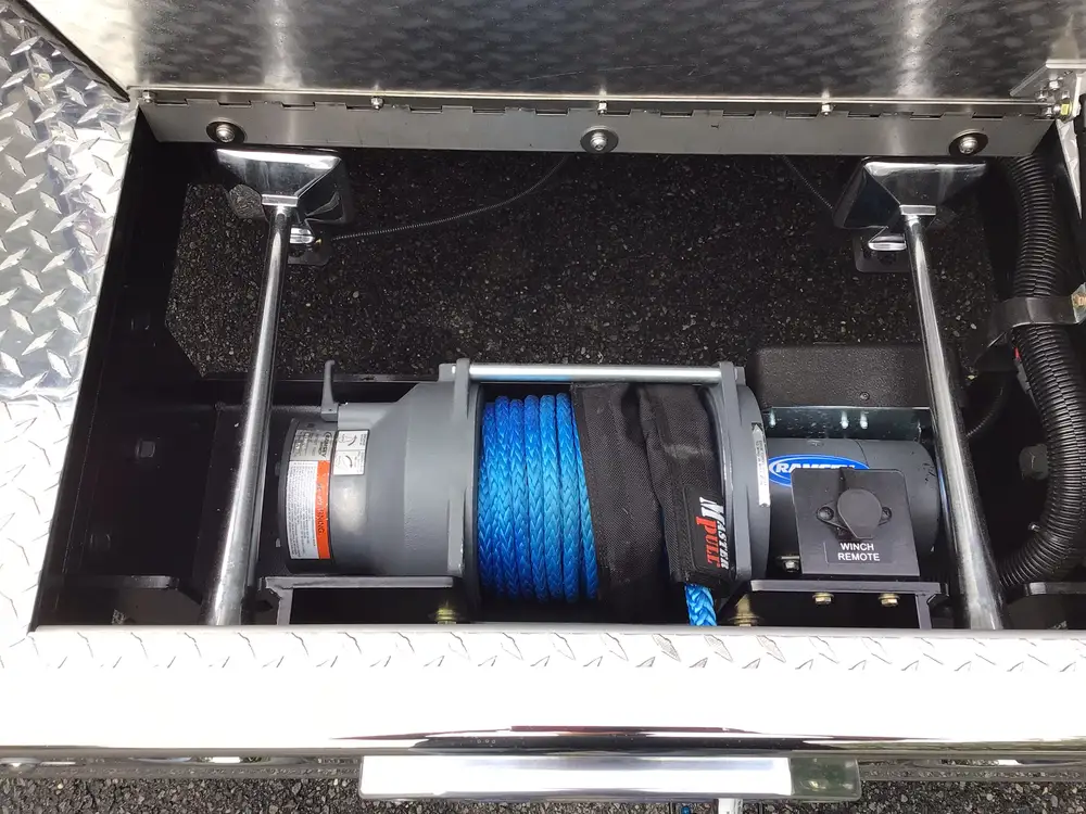 Underbody compartment close-up showing winch spool with blue synthetic rope
