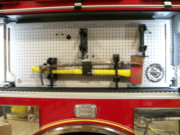 Open compartment showing long-handled tools and mounted hand tools