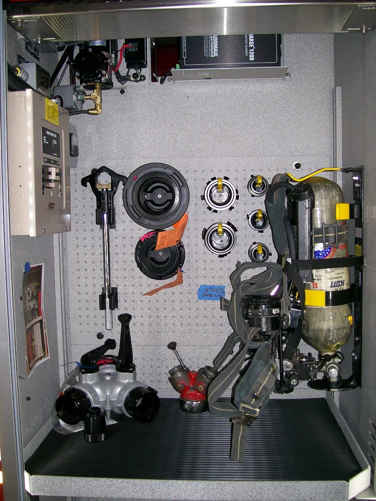 Interior equipment bay showing pump components, hoses, and mounted controls