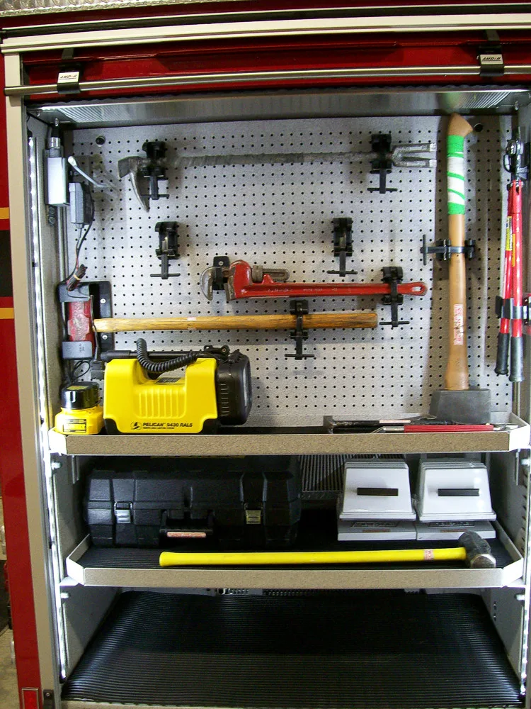 Open compartment showing power tools, batteries, and charging equipment