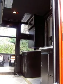 Interior command area view showing cabinets, desktop surfaces, and front cab opening