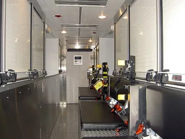 Interior rear aisle view showing seating and secured SCBA gear along wall