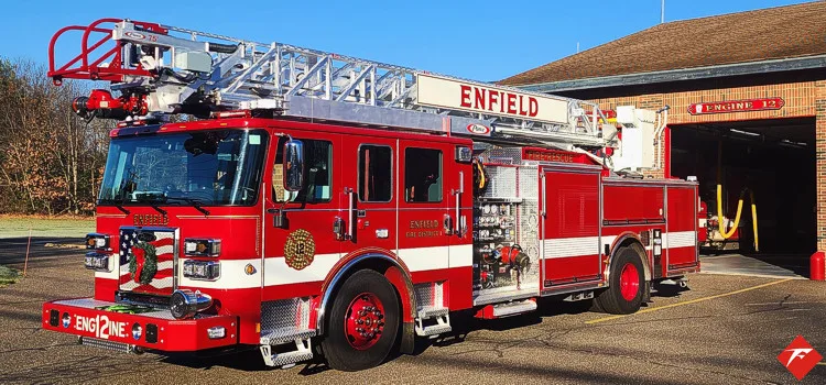 Aerial ladder truck side profile parked in front of station bays