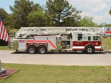 Driver-side full profile showing tandem rear axles and ladder bed