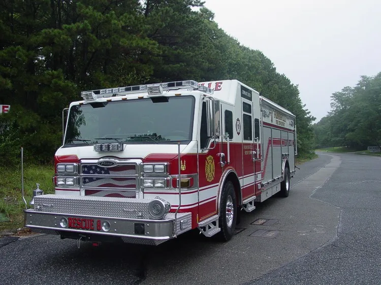Front left angle showing grille, warning lights, front bumper equipment mount, and side compartments.