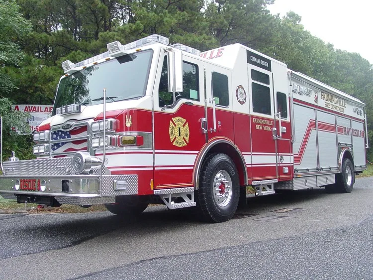 Low front left view highlighting the chrome bumper, cab step area, and right-side compartment doors.