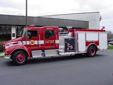 Passenger-side full profile showing pumper body, side compartments, and wheel layout