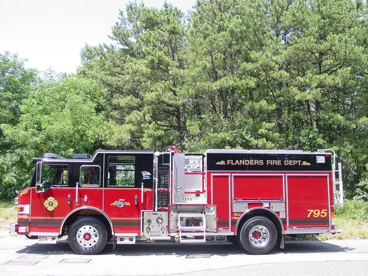 Full right-side profile of the pumper with pump panel zone, roll-up compartments, and rear wheel area.