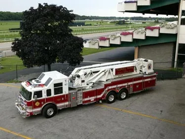 Elevated side view showing aerial ladder truck parked near station