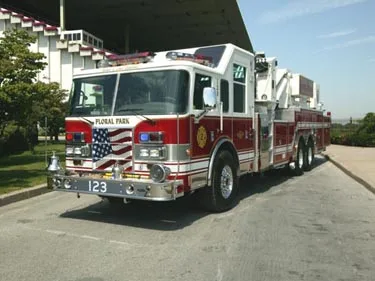 Aerial ladder truck front-left exterior view showing bumper and ladder base