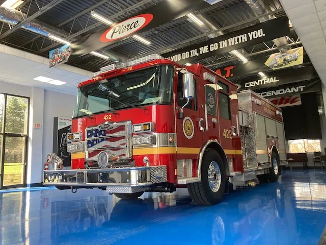 Front-right exterior view indoors showing bumper, cab, and side body