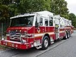 Aerial ladder truck front-left exterior view showing cab and ladder bed