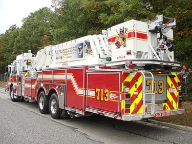 Rear-right exterior view showing chevrons, ladder bed, and rear body