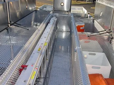 Roof walkway view showing diamond-plate deck and mounted ladder channel