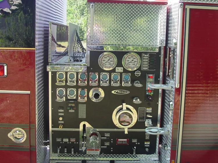 Pump panel close-up showing gauges, valve controls, intake and discharge fittings, and control labels.