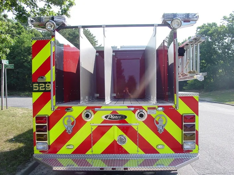 Straight rear view showing open rear hosebed bays, rear chevrons, and rear intake fittings.