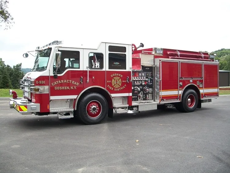 Front-left exterior view showing the cab face, pump panel controls, and side compartment doors.