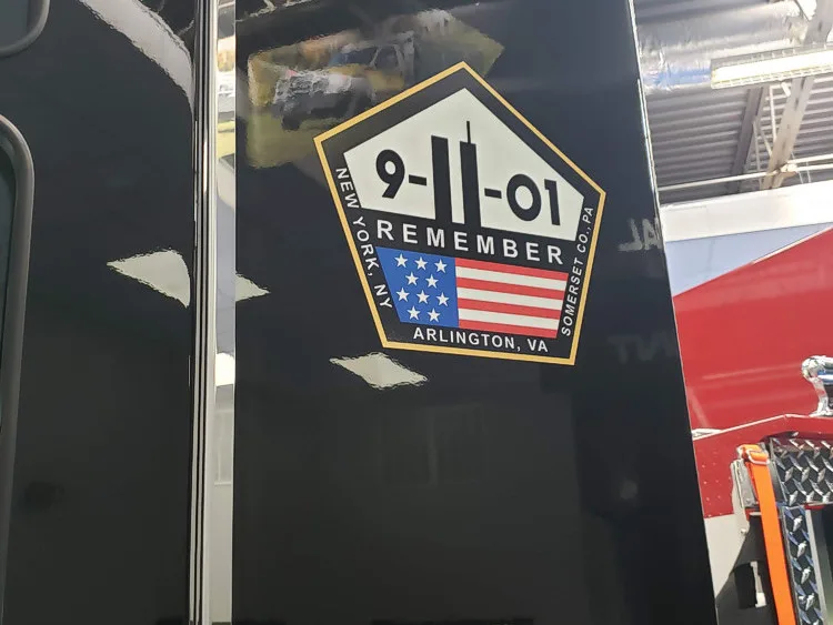 Body patch close-up showing memorial-style shield graphic on dark background