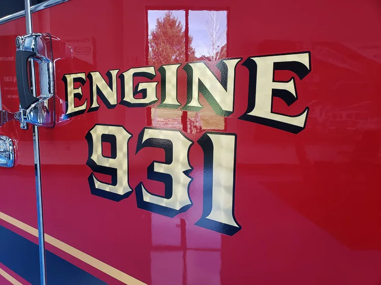 Body side close-up showing raised unit lettering on red paint
