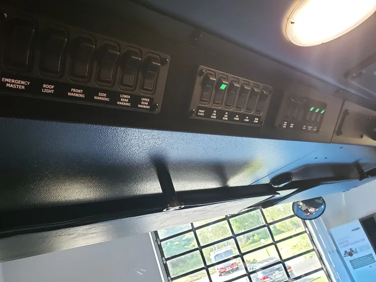 Cab overhead console close-up showing rocker switches and labels