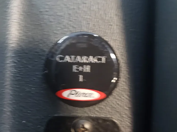 Cab interior trim close-up showing circular department pin on seat panel