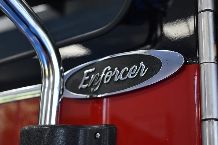 Body badge close-up showing Enforcer emblem on red panel