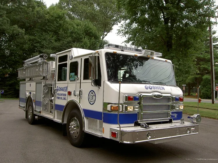 Front-left exterior view showing cab, bumper, and side body