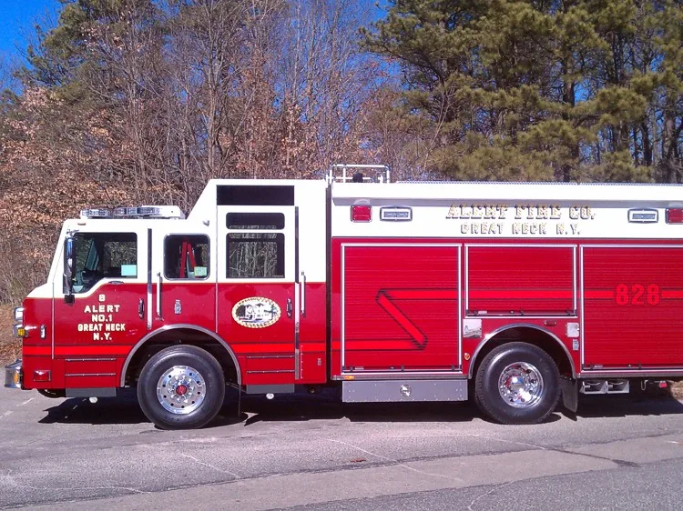 Driver-side full profile showing the enclosed cab, side roll-up compartments, and wheelbase.