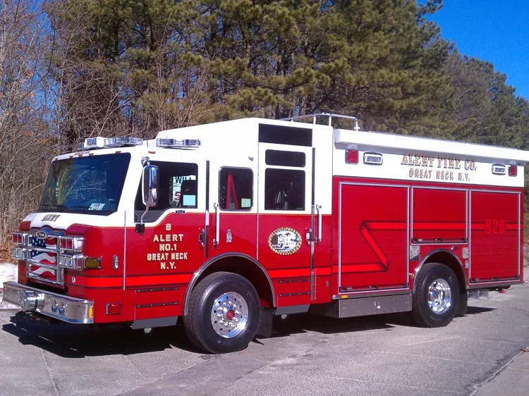 Front-left wide view showing the pumper cab face, side compartments, and rear body section.