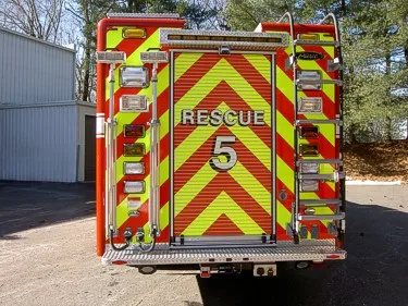 Rear view showing red-yellow chevrons, rear door, and ladder rails