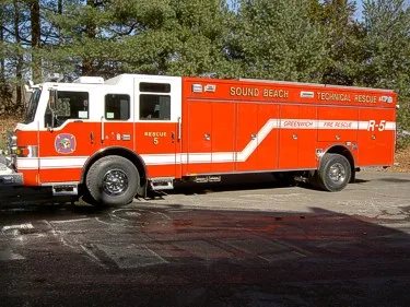 Driver-side full profile showing rescue body, side compartments, and wheel layout