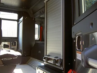 Cab interior rear area showing bench seat and roll-up storage door