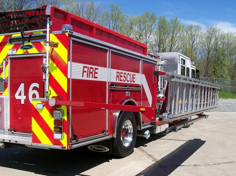 Rear-right exterior view showing side hosebed rails, rear panel, and wheel area