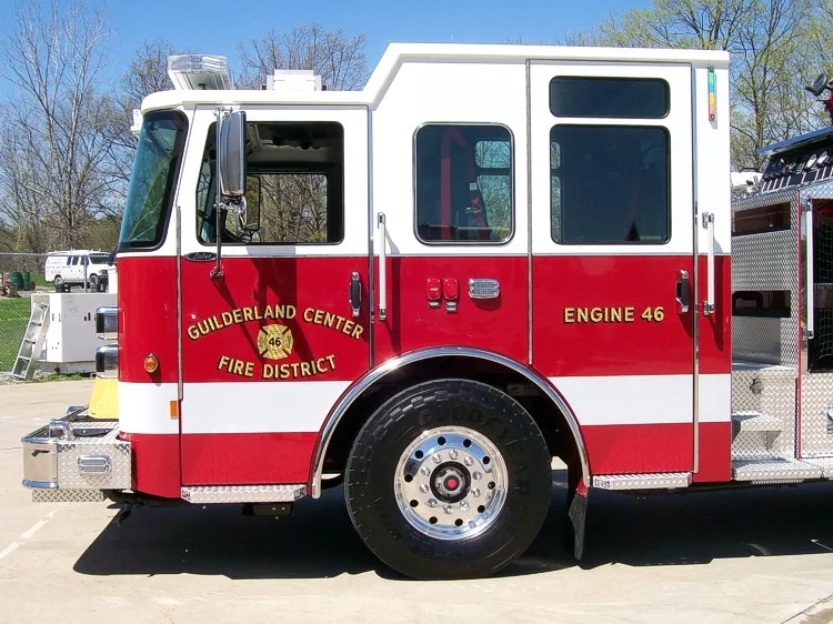 Cab side close-up showing door logo, side window, and front wheel