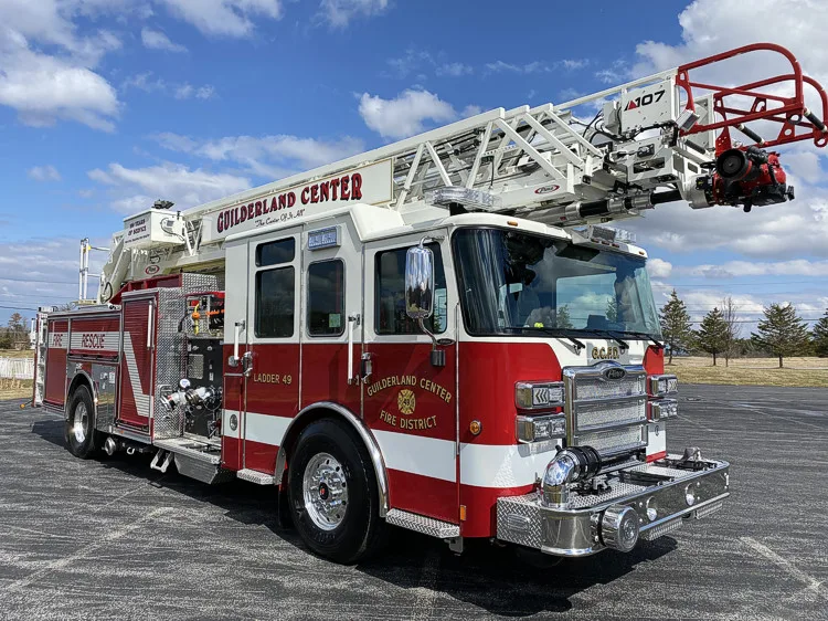 Tower ladder truck front-left exterior view showing cab and ladder bed
