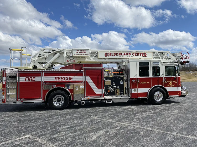 Driver-side full profile showing ladder bed, side body, and tandem wheels