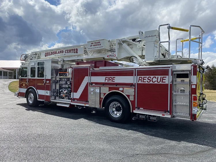 Rear-left exterior view showing tower ladder body and side compartments