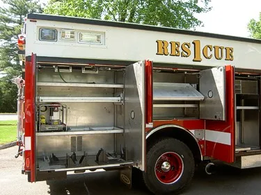 Passenger-side compartment close-up showing open storage shelves and pull-out tray