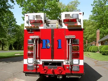 Rear view showing closed rear doors, warning lights, and rear hitch area