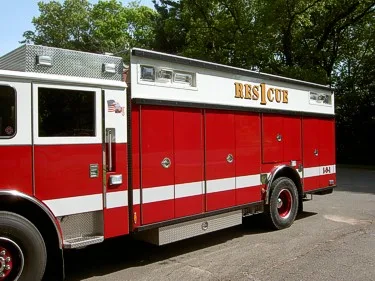 Passenger-side profile view showing long rescue body and side compartment doors