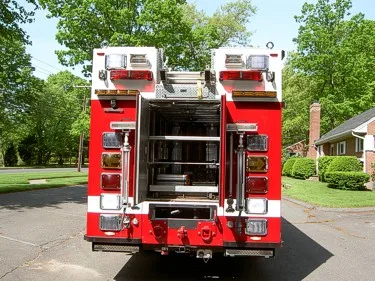 Rear view with rear doors open showing interior rescue storage rack system