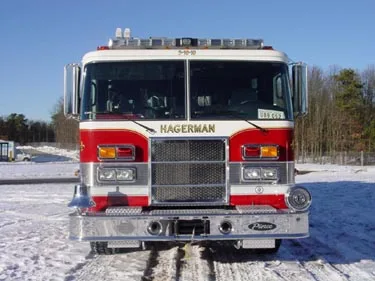 Head-on front view showing grille, bumper, and warning light bar