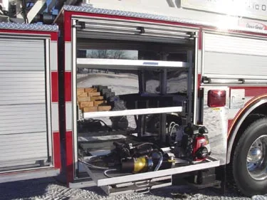 Open side compartment showing shelves with tools and rescue equipment