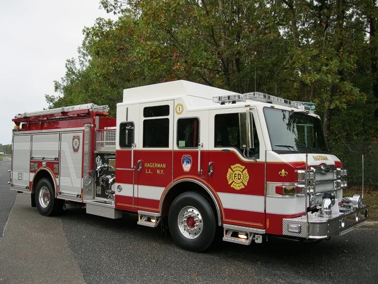 Front-right wide view showing the cab, bumper, pump panel area, and side compartment doors.