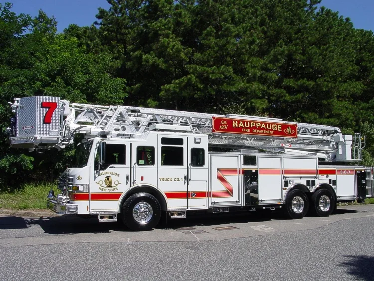 Driver-side full profile showing the stowed aerial ladder, side body compartments, and tandem wheel area.