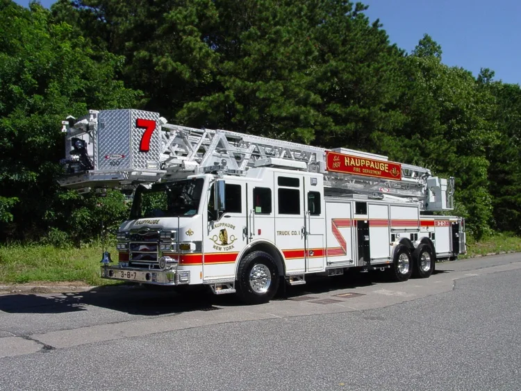 Front-left wide view showing the cab, aerial ladder bed, and full side body profile.