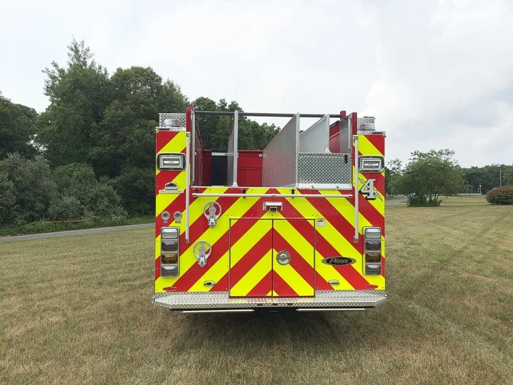Straight rear view with red-yellow chevrons, rear door panel, and rear warning lights.