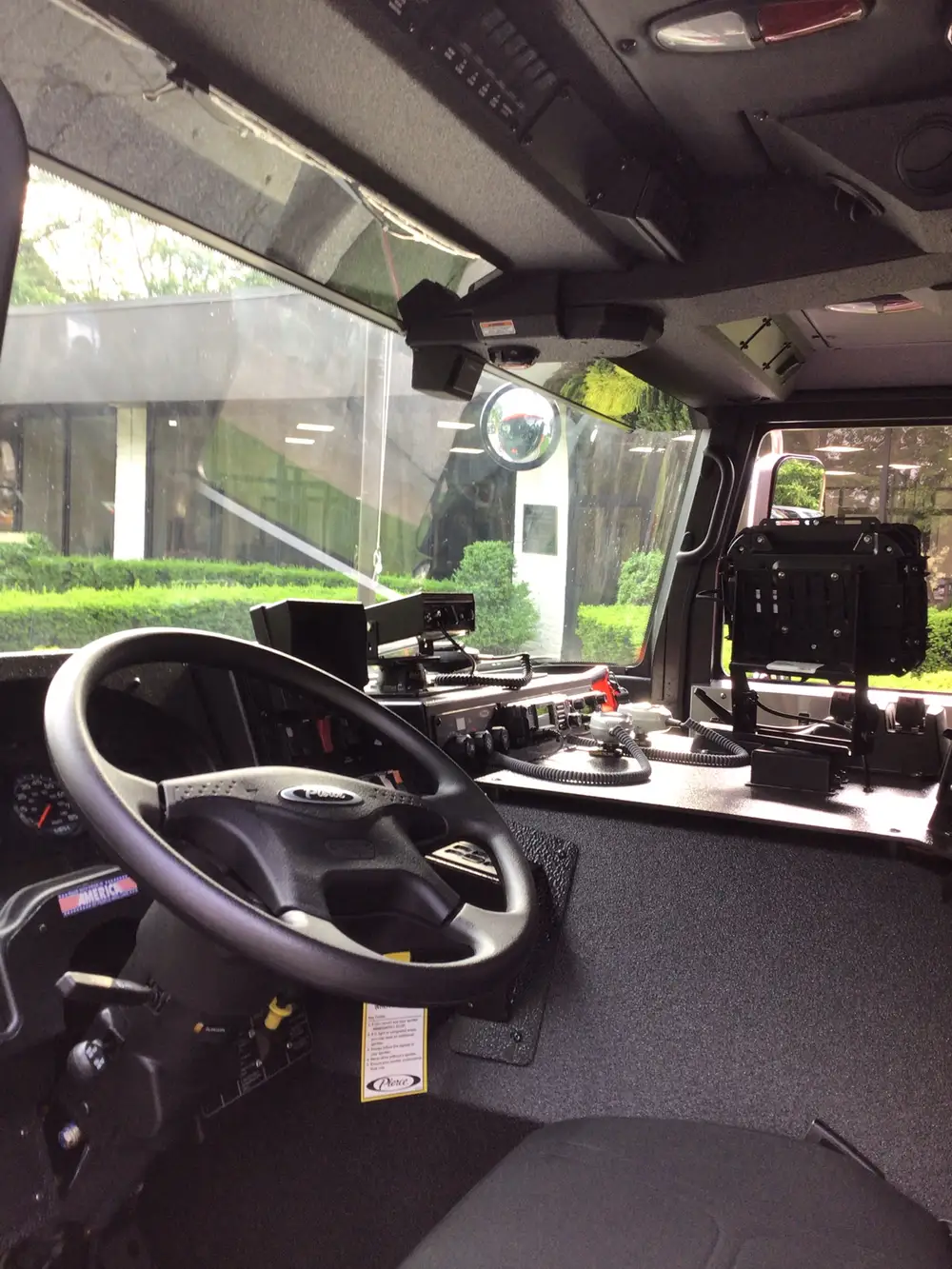 Driver cockpit view showing steering wheel, dash controls, and radio mounts