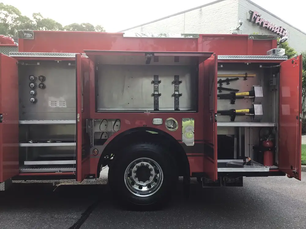 Driver-side compartments open around rear wheel with tool mounts and shelves