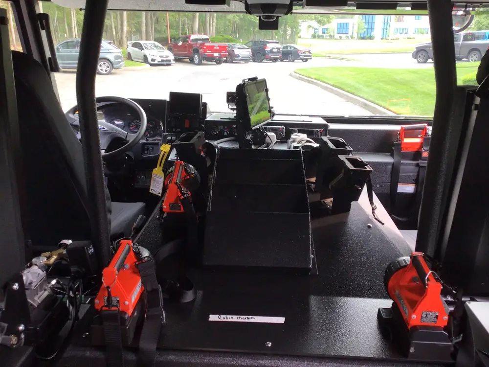 Cab interior wide view from rear showing console, tablet mount, and chargers